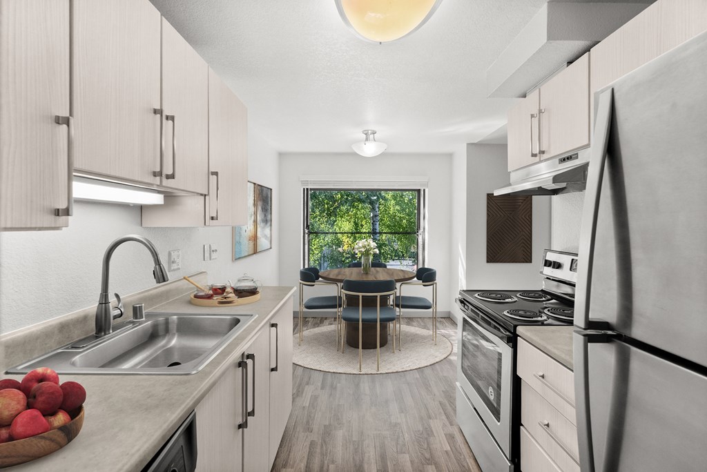 A modern kitchen with a dining table and chairs in the middle.