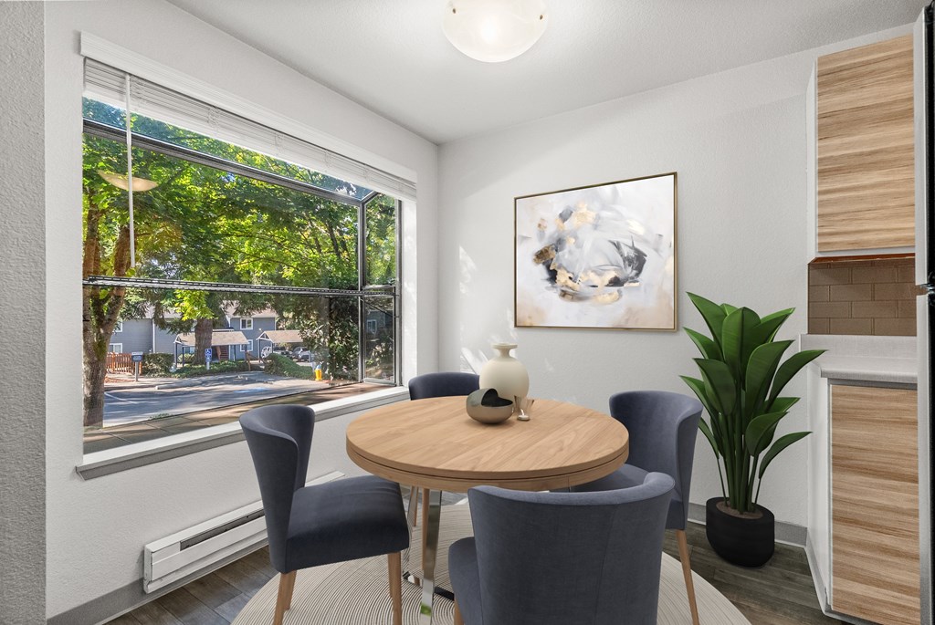 A room with a table, chairs, and a painting on the wall.