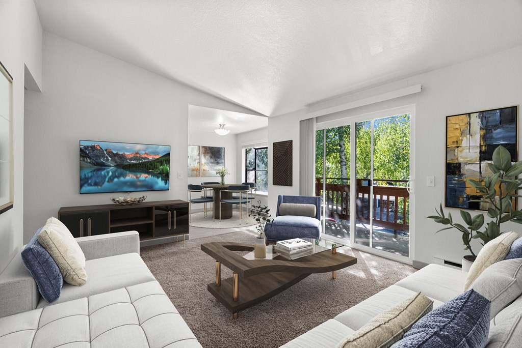 A modern living room with a large painting on the wall and a view of the outdoors through the sliding glass doors.