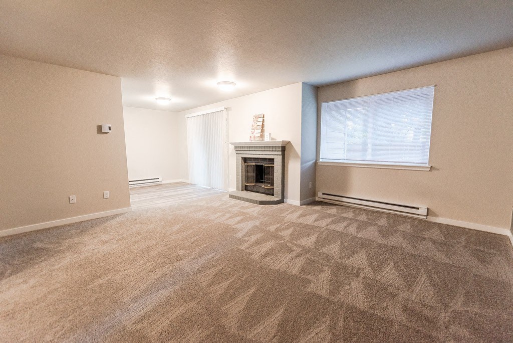Puyallup Apartments - Cambridge on Seventh Apartments - Living Room, Fireplace, and Dining Room at Cambridge on Seventh, Puyallup, WA, 98372