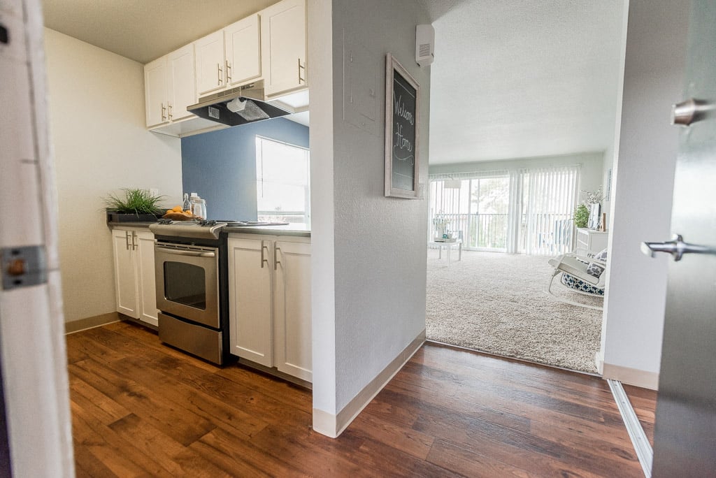 A kitchen with a stove top oven and a fridge.