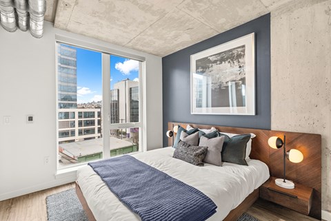 A bedroom with a large bed and a view of the city.