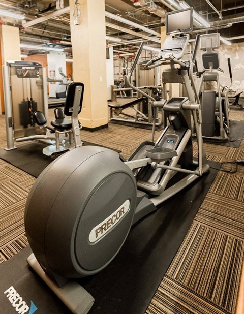 A Precor exercise bike is on a black mat in a gym at Addison on Fourth Apartments, Seattle, WA, 98104