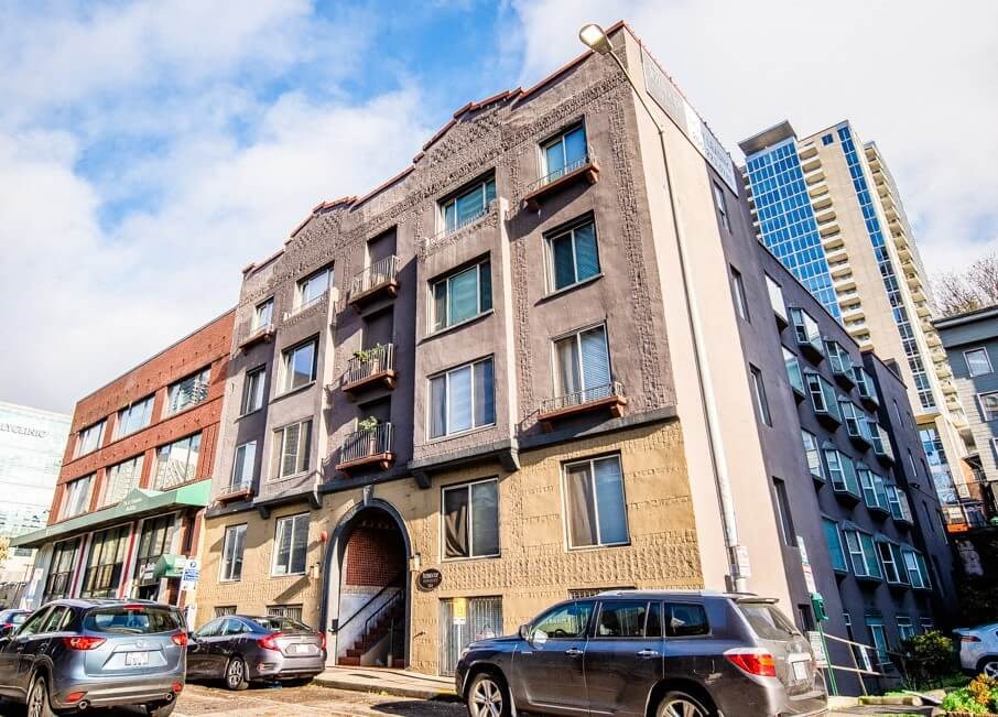 A large, old building with a lot of windows is in front of a modern building. at Zindorf, Seattle, Washington