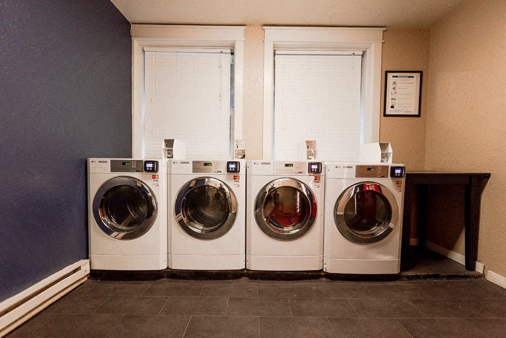 Three front load washing machines in a laundry room. at Zindorf, Seattle, Washington