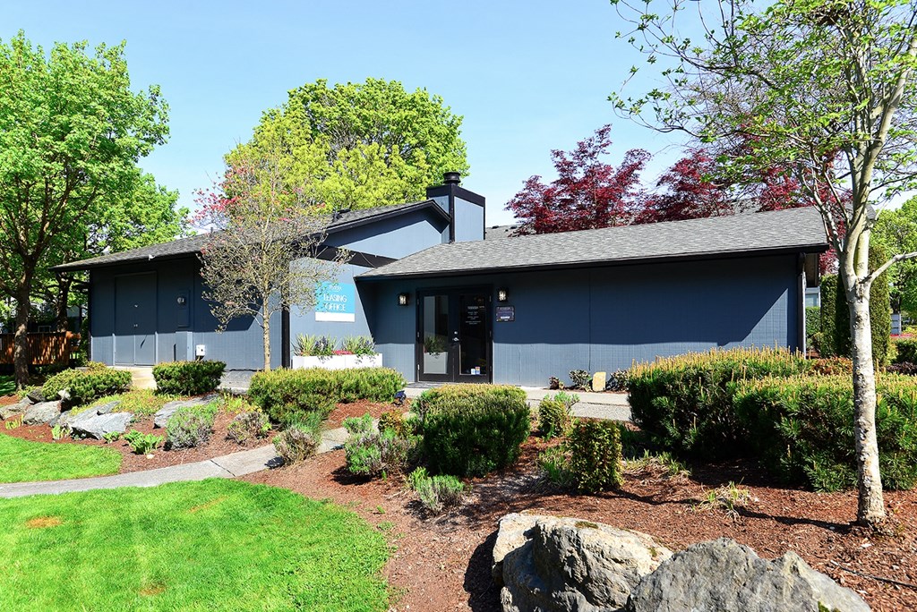 a blue building with a landscaped garden in front of it