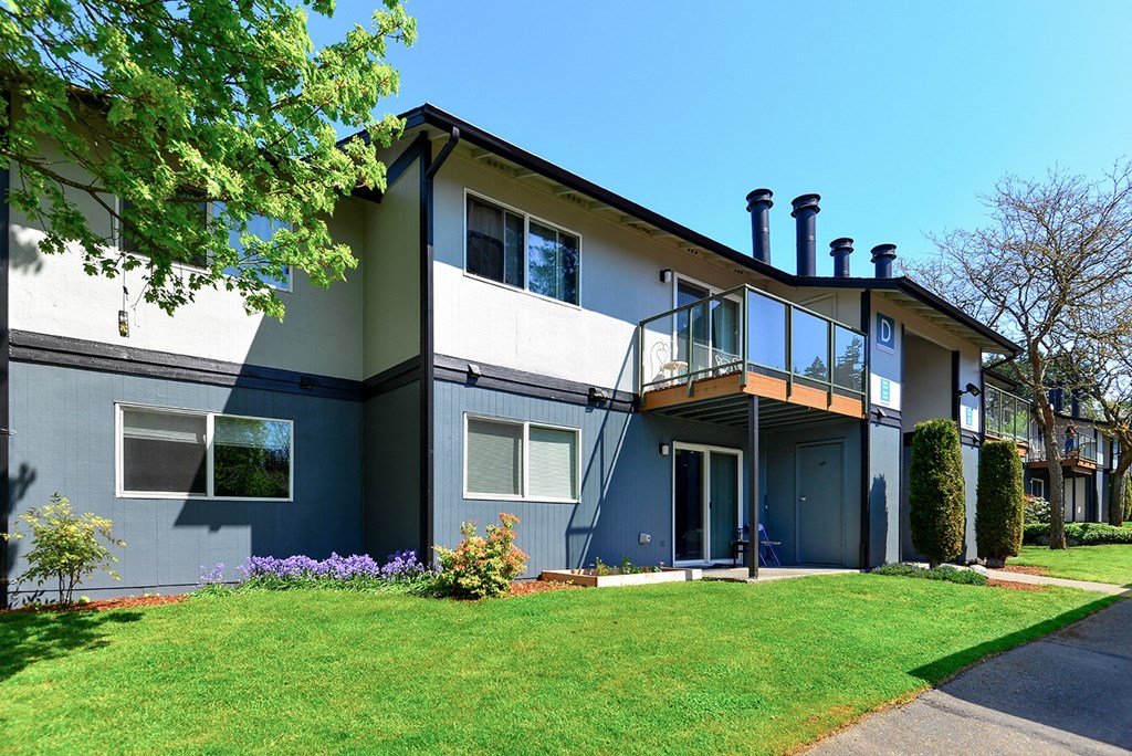 a home with a gray and white exterior and a green lawn