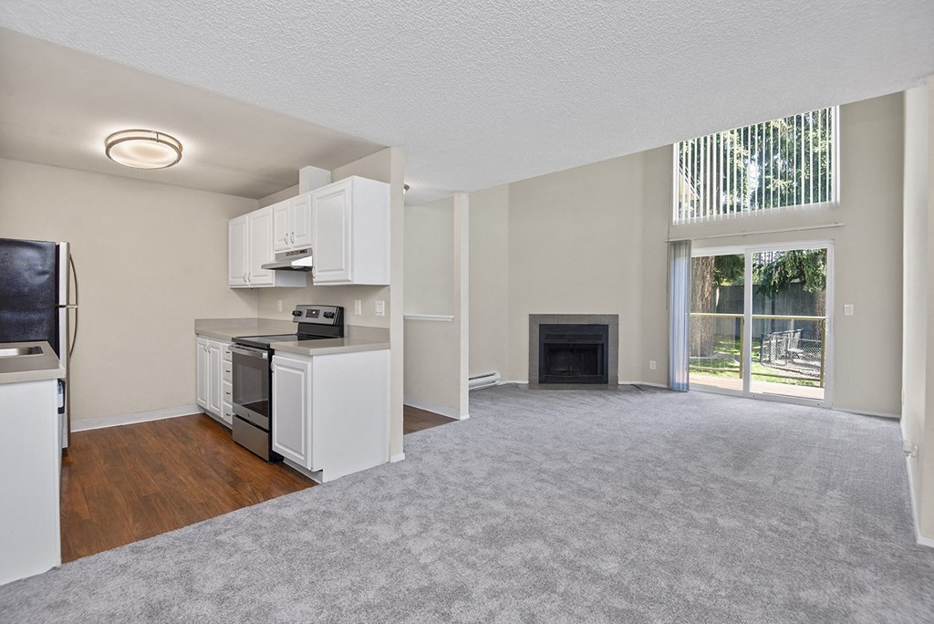 a living room with a fireplace and a kitchen