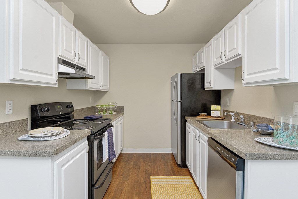 a kitchen with white cabinets and black appliances
