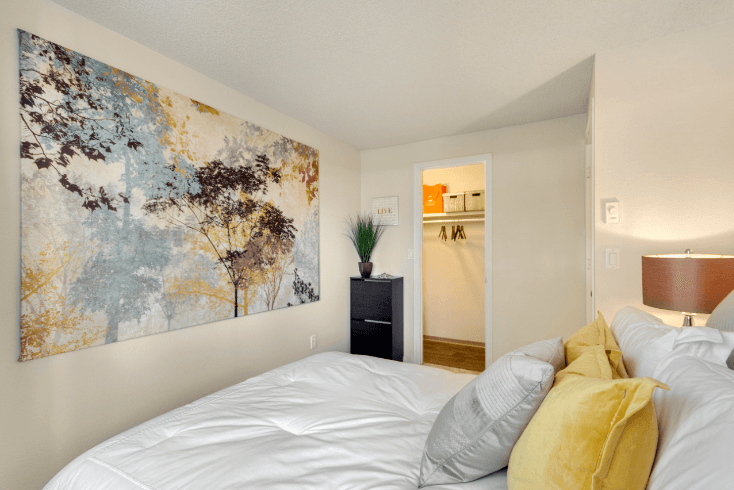 A bedroom with a large painting on the wall and a bed with white sheets and yellow pillows. at The Retreat, Washington