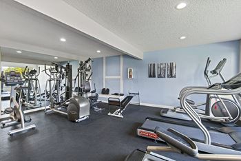 A gym with a variety of exercise equipment including treadmills, weights, and exercise machines. at The Verandas, Tacoma