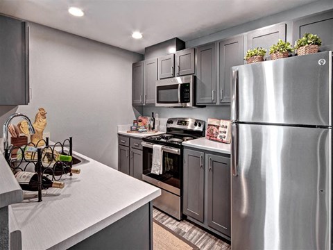 a kitchen with stainless steel appliances and gray cabinets