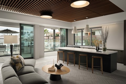 A modern living room with a grey sofa and a wooden ceiling.