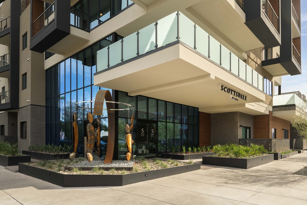 A modern building with a sculpture in front of it.