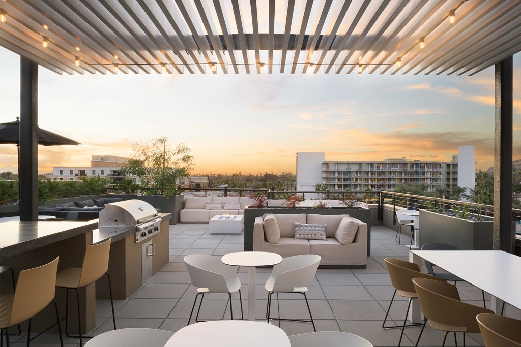 A rooftop patio with a bar and seating area.