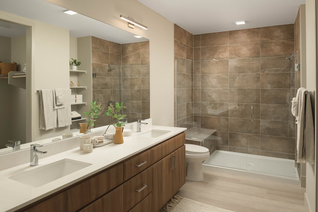 A bathroom with brown tiles and a white sink.