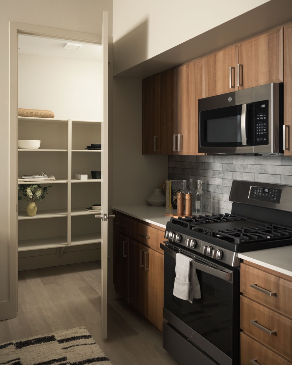 A modern kitchen with a black stove and wooden cabinets.