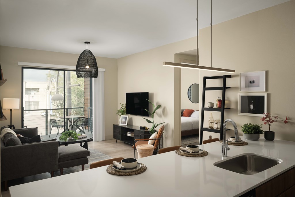 A modern kitchen with a dining area and a living room.