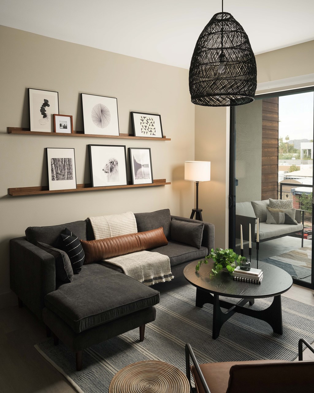 A living room with a grey couch, a coffee table, and a lamp.
