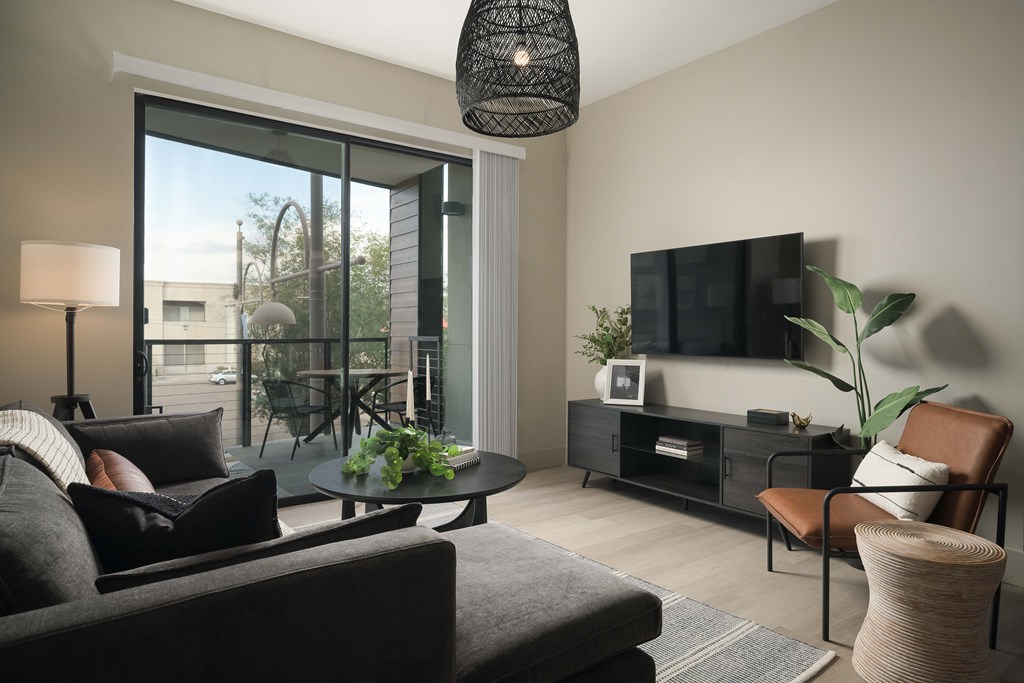A living room with a grey couch and a black lamp.