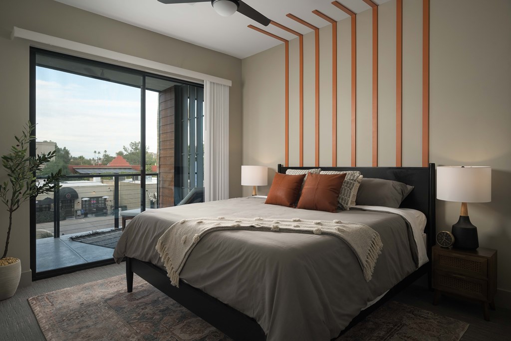 A bedroom with a large bed and a ceiling fan.