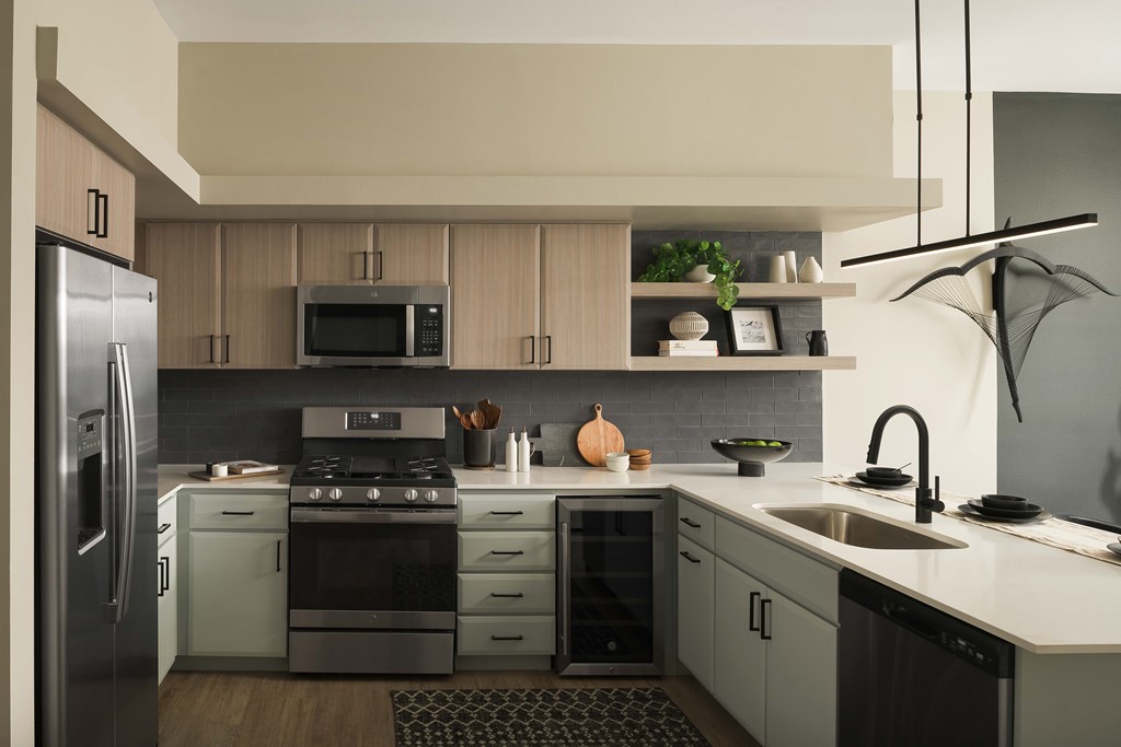 A modern kitchen with a refrigerator, stove, and sink.