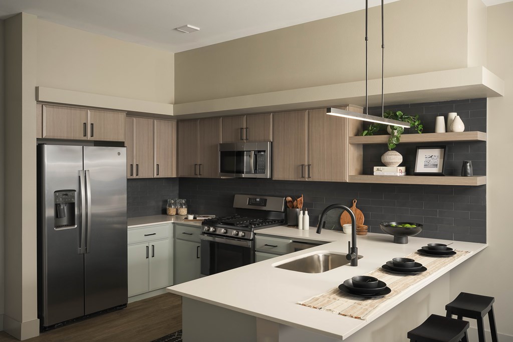 A modern kitchen with a stainless steel refrigerator and a white countertop.