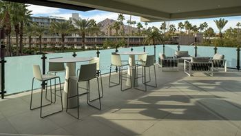 A patio with chairs and a table is set up on a balcony.