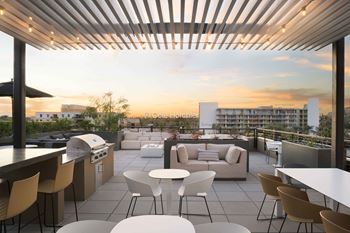 A rooftop patio with a bar and seating area.