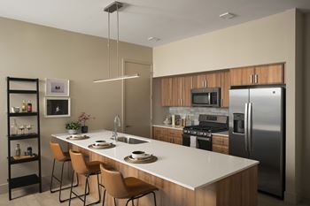A modern kitchen with a white countertop and stainless steel appliances.