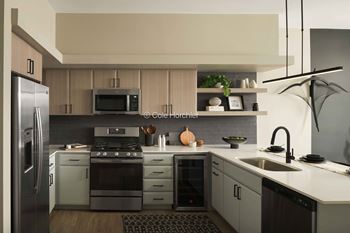 A modern kitchen with a refrigerator, stove, and sink.