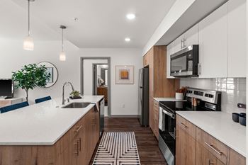 a large kitchen with white counter tops and wooden cabinets at Gage On Sixth, Washington, 98406