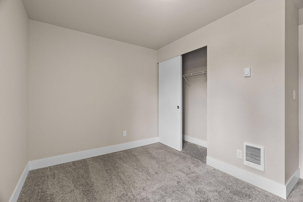 an empty bedroom with a closet and a carpeted floor at Bellamy Park Apartments , Lakewood, CA, 98498