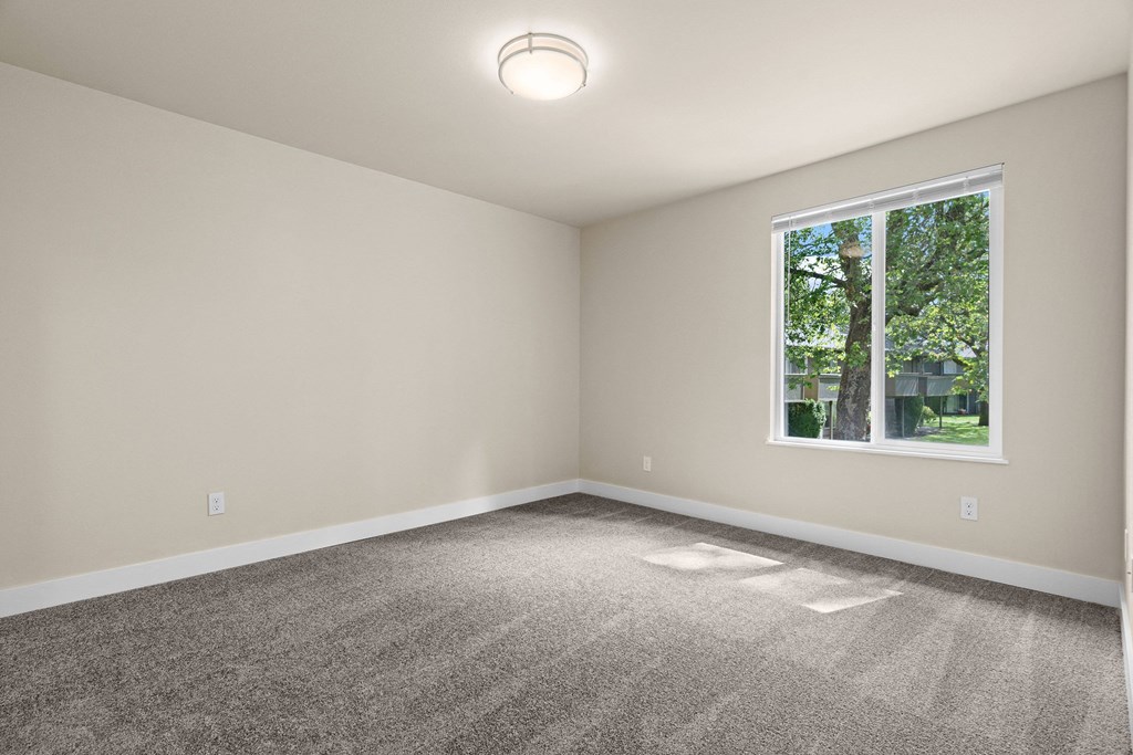 an empty room with carpet and a window at Bellamy Park Apartments , Lakewood, CA, 98498