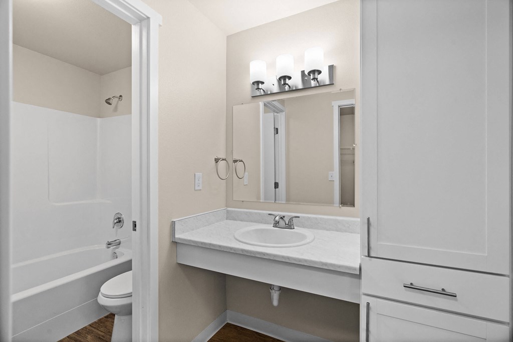 a bathroom with a sink and a mirror and a shower at Bellamy Park Apartments , Lakewood, CA