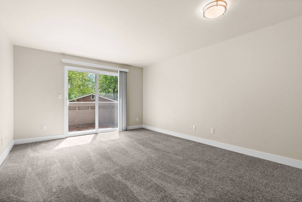 an empty living room with a large window and carpet at Bellamy Park Apartments , Lakewood, CA, 98498