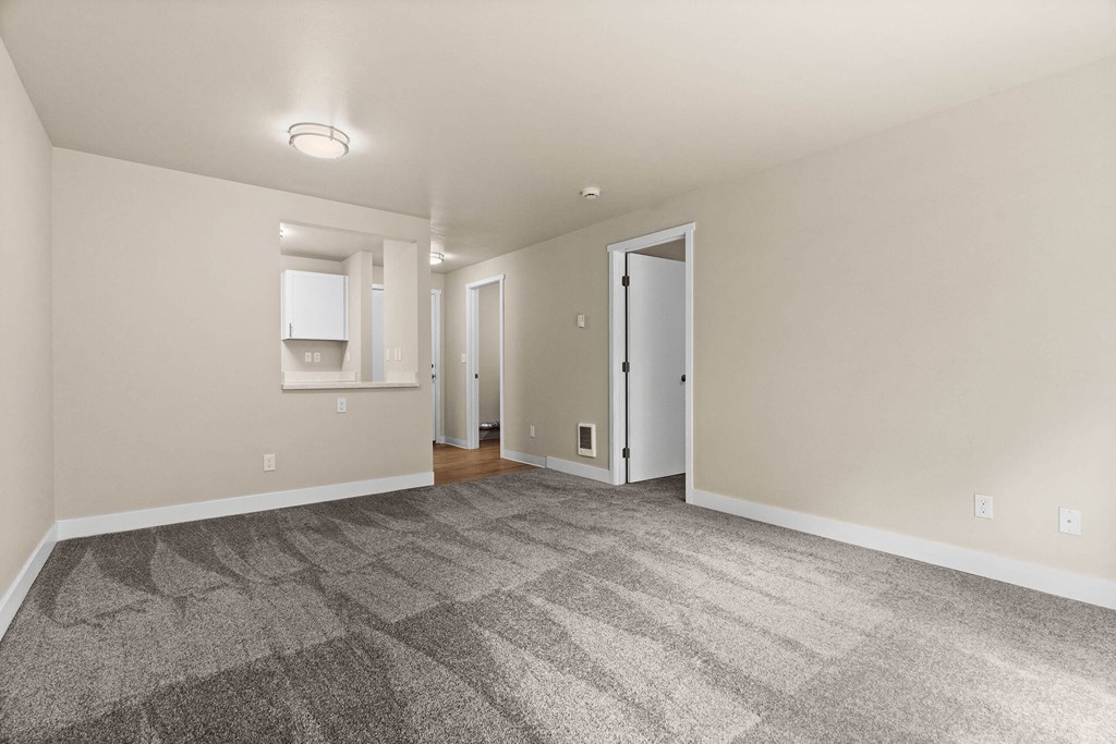 a living room with carpet and a door to a kitchen at Bellamy Park Apartments , Washington