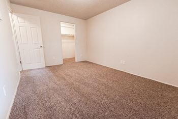 an empty bedroom with carpeting and a white door at Bellamy Park Apartments , Lakewood, Washington