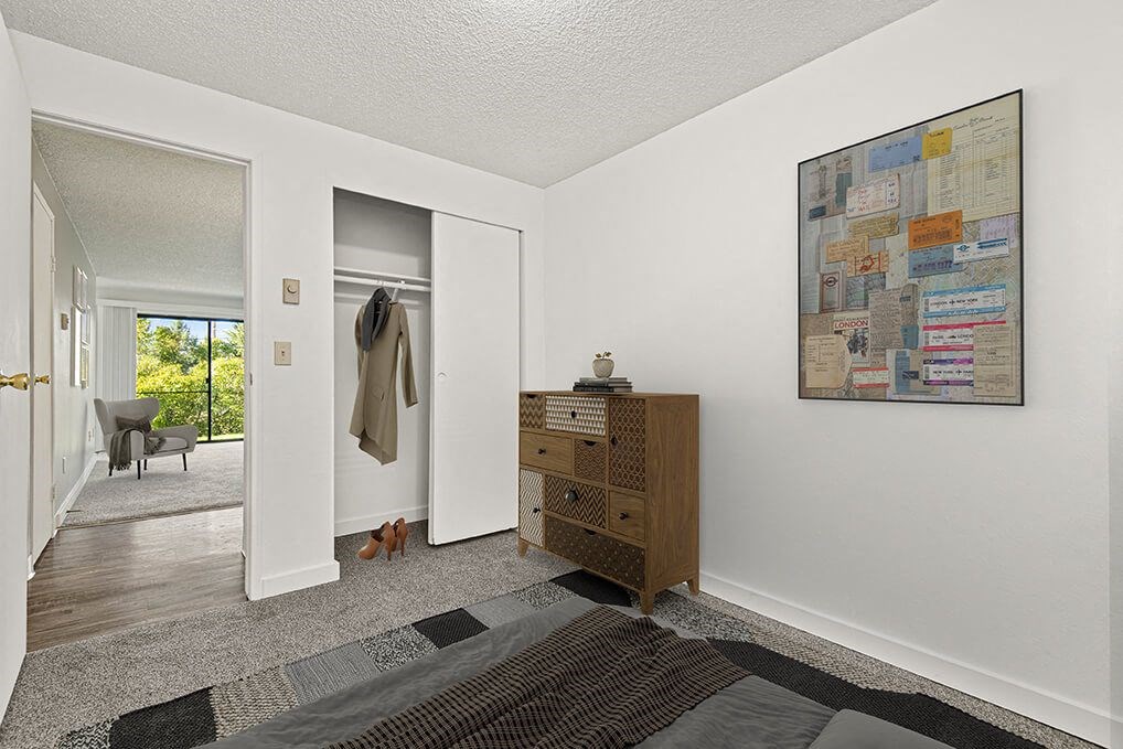 a living room with a dresser and a door to a closet