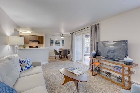 A living room with a white couch and a wooden coffee table.