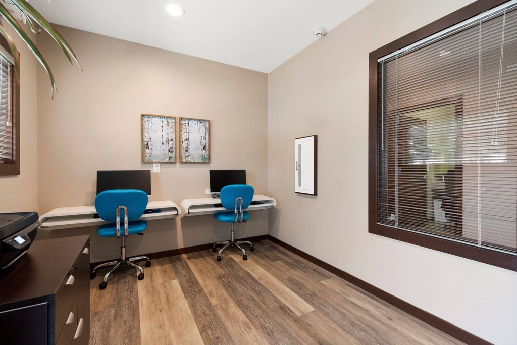 A room with two chairs and a desk.