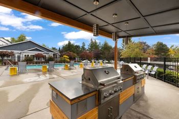 A barbecue grill is in the middle of a patio.