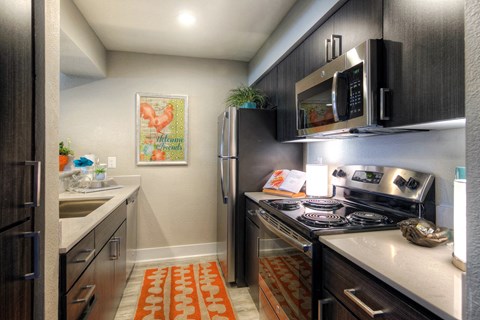 A kitchen with a stove top oven and a refrigerator.