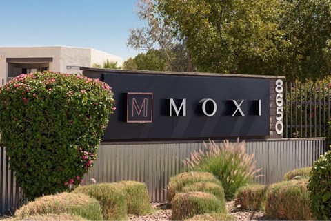 A sign that says Moxi in front of a building.
