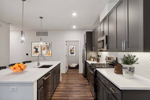 A modern kitchen with dark wood cabinets and white countertops.