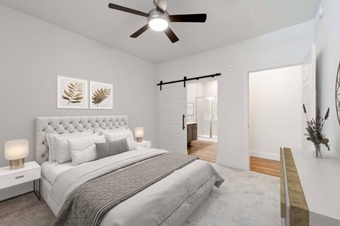A bedroom with a large bed and a ceiling fan.