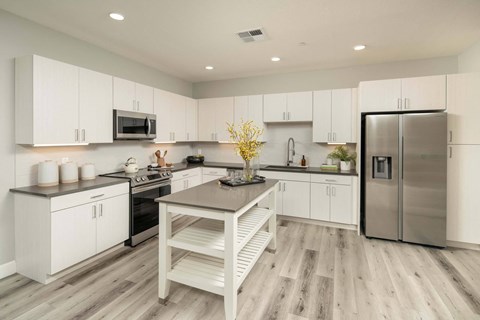 A modern kitchen with white cabinets and a wooden island.