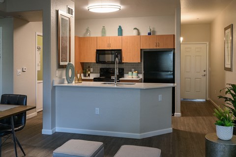 A kitchen with a black counter top and a white island.