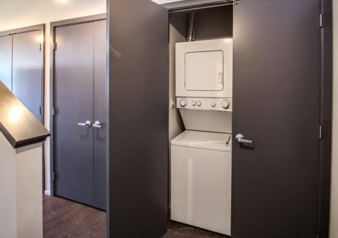 A white oven is built into a dark brown cabinet.