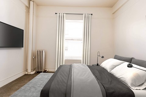 A bedroom with a large bed and a flat screen TV mounted on the wall. at Addison on Fourth Apartments, Washington, 98104